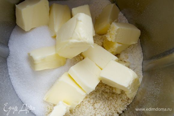 Приготовим тесто. В чашу миксера просеять муку, добавить сахар, миндальную муку и охлажденное сливочное масло кусочками.