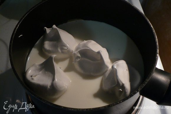 Молоко доводим до кипения, оно должно быть горячим, но не кипеть. Выкладываем ложкой меренги и варим примерно по 2 минуты с каждой стороны.