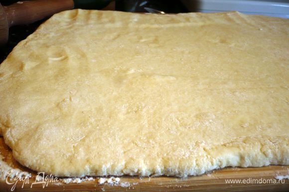 Выложим тесто на хорошо присыпанную мукой поверхность, тесто присыпем сверху также мукой и раскатаем в прямоугольный пласт примерно 35 на 25 см.