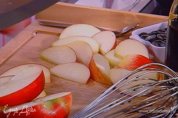 Листья салата вымыть, высушить, разложить на тарелки. Яблоки (желательно плотные, кисло сладкие и красные) порезать дольками. Смешать тыквенное масло с тёмным балзамиком, мёдом и солью.