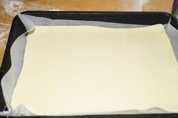 Слоеное тесто, если оно из морозилки, необходимо разморозить, немного раскатать на припыленой мукой поверхности. Выложить на противень застеленный пергаментом.