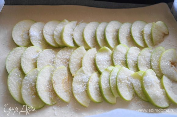 Яблоко нарезать тонкими пластинами, и выложить на пласт теста, присыпать немного сахаром.