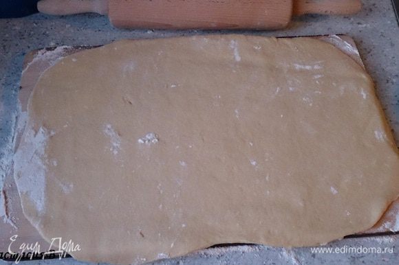 Раскатать тесто прямоугольной формы на посыпанной мукой поверхности.