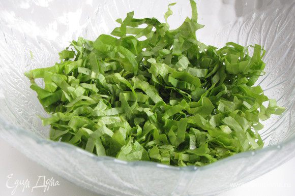 Салат-латук или другой листовой салат очень тонко порезать и выложить в миску.