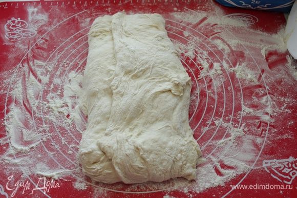 Растянуть тесто,затем сложить тесто в конверт: сперва вдвое.