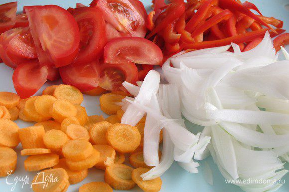 Очистить овощи. Два средних луковицы нарезать тонкими перьями, морковь - кружочками, сладкий перец - полосками, помидоры - дольками.