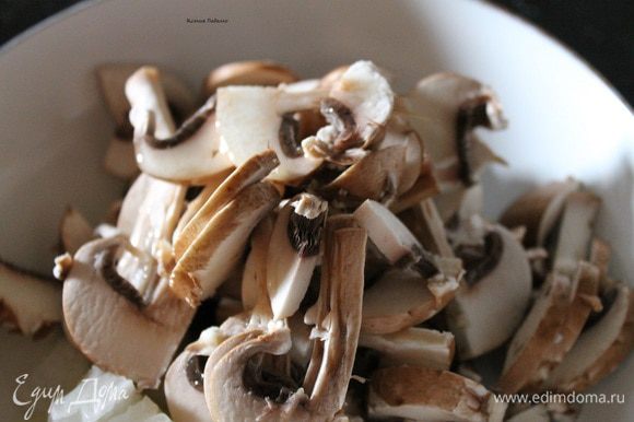 Разрезать каждый гриб пополам, а потом тонкими пластинками. Сложить к луку в сковородку, добавить 3 ст.л. растительного масла. Обжарить до слегка золотистого цвета.