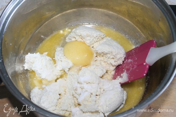 Растапливаем 50 г сливочного масла, добавляем отжатый творог, соль, соду и яйцо и быстро и тщательно смешиваем до однородности.