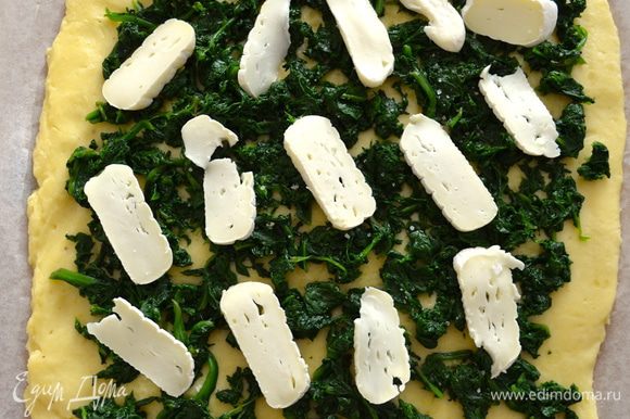 Нарезать пластинками сыр и тоже распределить поверх шпината. Присыпать все тертым Пармезаном.
