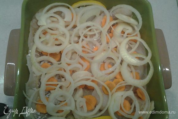 Выложить лук и морковь на рыбу.