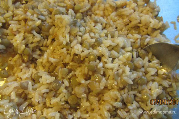 Когда рис и чечевица готовы, сливаем с чечевицы воду, выкладываем их в салатницу и горячими заправляем заправкой. Перемешиваем и так оставляем.