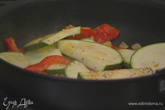 Выложить к овощам кабачок, немного посолить, поперчить и перемешать, затем уменьшить огонь и жарить 2–3 минуты.