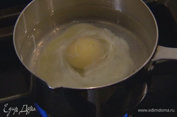 Приготовить яйцо пашот: в небольшой кастрюле вскипятить 500 мл воды, добавить уксус, с помощью венчика сделать маленький водоворот и в центр воронки вылить яйцо. Убавить огонь и варить 2–3 минуты, затем шумовкой выложить яйцо на бумажное полотенце.