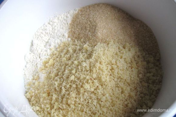 Просеять пшеничную муку, добавить сахарный песок, ванильный сахар и измельченный миндаль.