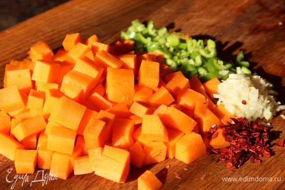 Морковь нарезаем кубиком, горький перец и чеснок рубим и отправляем к мясу. Добавляем лепестки перца чили или просто сушеный красный острый перец, тимьян.