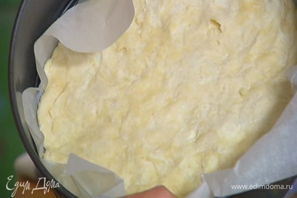 Разъемную форму выстелить бумагой для выпечки и равномерно распределить тесто, так чтобы получились небольшие бортики. Часто наколоть тесто вилкой и выпекать в разогретой духовке 15 минут.