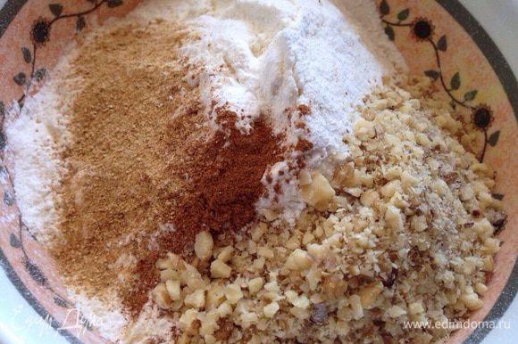 Муку просеять в миску, смешать с разрыхлителем, солью, специями и молотыми грецкими орехами.