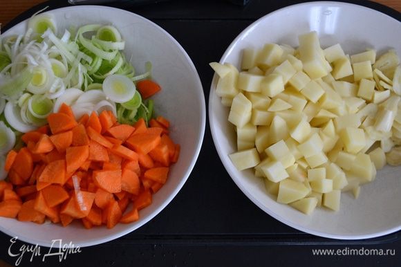 Подготовить овощи. Вымыть, очистить... Лук порей нарезать кольцами, морковь и картофель - небольшими кубиками, чеснок - "лепестками".