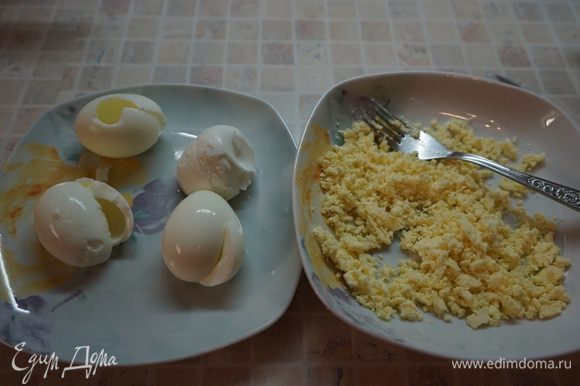 Разморозить тесто. Поставить вариться 4 яйца в подсоленную воду. Яйца охладить, почистить. Разрезать белки до желтка, достать желтки.