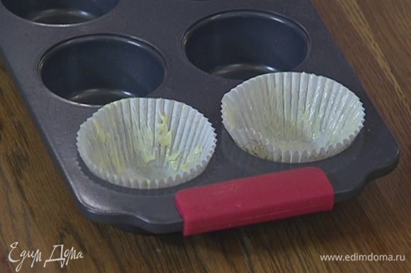 Бумажные вкладыши для кексов смазать оставшимся сливочным маслом и вложить их в формочки.