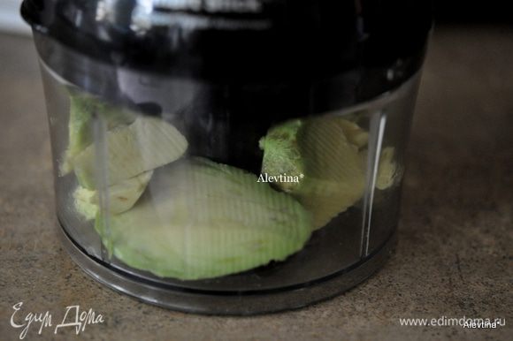 Очистить авокадо от кожуры и ядра. Мякоть выложить в кухонный процессор, добавить дольку чеснока.