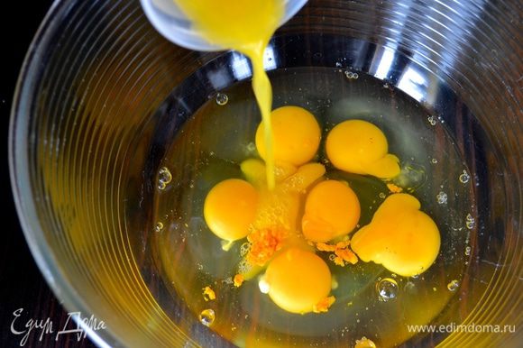 Два апельсина вымыть и натереть цедру. Выдавить 50 мл сока. В огнеупорную форму разбить яйца, добавить цедру апельсинов и апельсиновый сок.