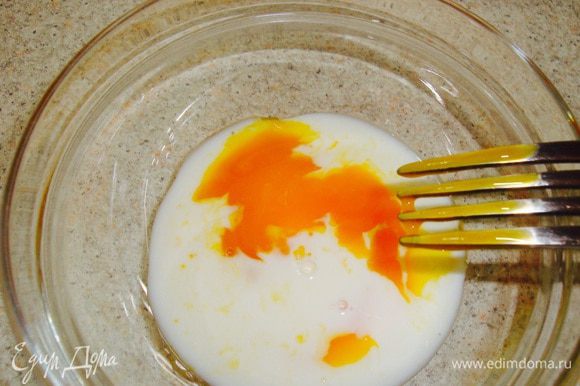 Смешиваем желток от одного яйца, который отложили, и одну столовую ложку молока.