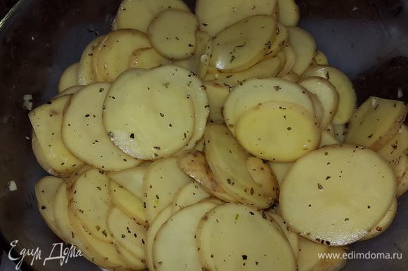 Картофель выкладываем в глубокую миску, солим, перчим, добавляем травы, чеснок, немного масла от вяленых томатов и перемешиваем руками.