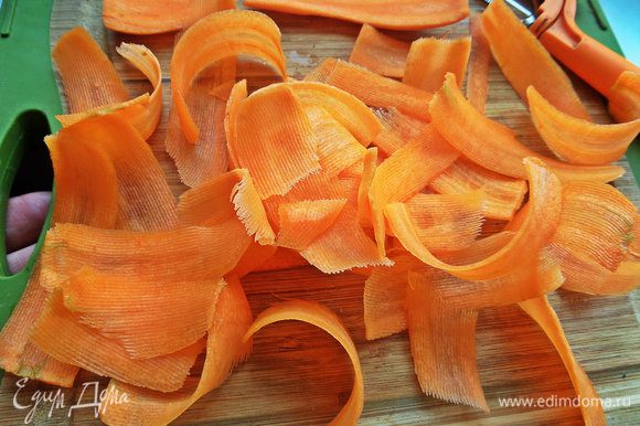 Нарезать морковь с помощью овощечистки на слайсы. Чем тоньше будут морковные слайсы, тем вкуснее.
