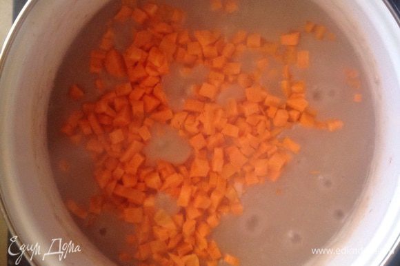 Очистить моркови и порезать кубиками. Добавить морковь в кастрюлю, перемешать, убавить огонь, накрыть крышкой и оставить тушиться 50-60 минут. В процессе тушения подливать воду.