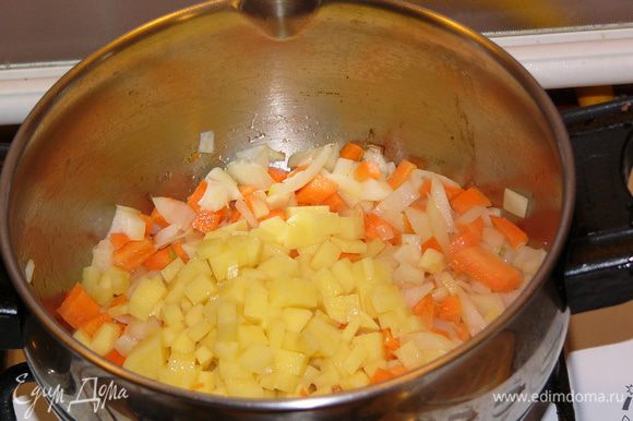 В кастрюле, где будет вариться суп, обжарить на оливковом масле лук, морковь, картофель около 3 минут.