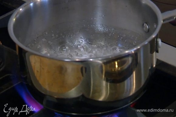 Сахар всыпать в небольшую кастрюлю, влить 50 мл воды и сварить светлый сироп.