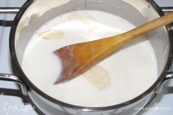 Разморозить тесто. Разогреть духовку до 180С. Почистить чеснок. Молоко и сливки влить в небольшую кастрюлю и, добавив чеснок, довести до кипения, затем убрать чеснок.