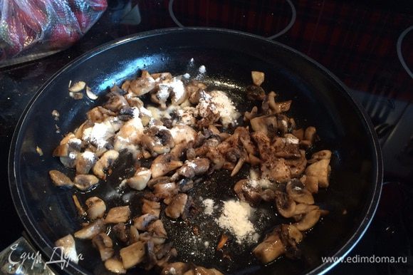 На раскаленную сковороду налейте растительное масло и обжарьте шампиньоны около 10 минут, сделайте огонь тише, посолите, приправьте перцем, мускатным орехом, добавьте муку, перемешайте.