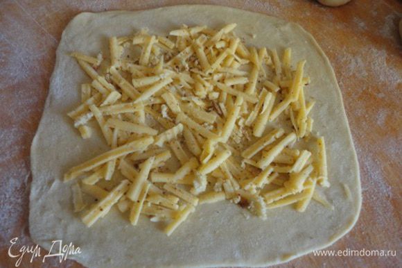 Тесто раскатать на порционные прямоугольники и посыпать смесью панировочных сухарей и твердого сыра, тертого на крупной терке.