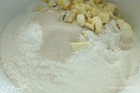 Муку просеять, добавить пакетик сухих дрожжей, щепоть соли и нарезанный кубиками охлажденный маргарин. Перетереть до состояния крошки.