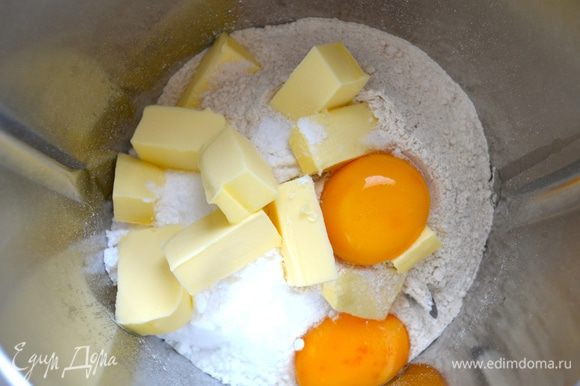 Для приготовления теста используем кухонный комбайн. В чашу миксера положите муку, кусочки охлажденного сливочного масла, яичные желтки, мелко натертую цедру половины лимона, сахарную пудру и щепотку соли. Включите комбайн и в течение нескольких секунд измельчите все до состояния мокрой крошки.