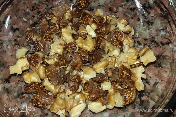 Инжир помыть и нарезать, смешать с порезанными грецкими орехами. Немного орехов также оставить для украшения.