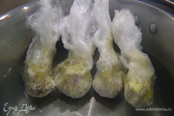 В большой кастрюле вскипятить воду, опустить все яйца в пленке и варить на медленном огне около 4 минут.
