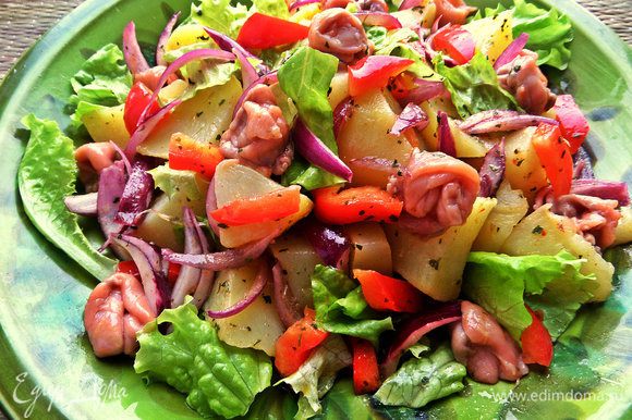Выложить салат на оставшиеся салатные листья, сверху-рыбку.