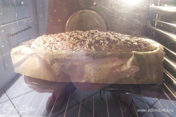 Смочить хлеб водой и поставить в холодную духовку на решётку. Включить на 180°С и выпекать 90 минут. Если верхушка начнёт сильно запекаться, накройте хлеб листом пергаментной бумаги.