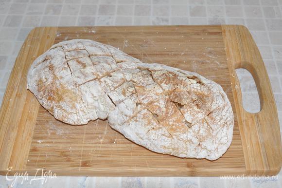 Острым ножом сделать на хлебе Х-образные разрезы, не прорезая низ хлеба. Уложить хлеб на фольгу.
