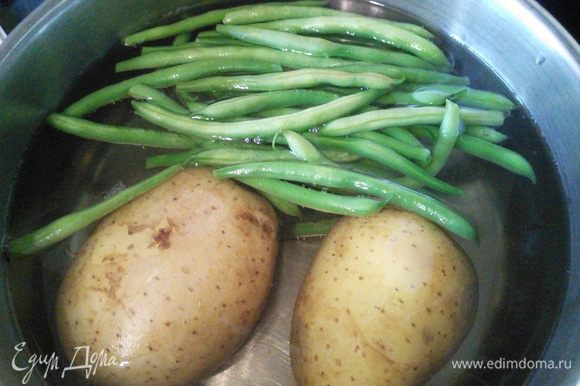 Картошку лучше сварить заранее, остудить. 5-7 минут до окончания варки картофеля бросить в воду стручковую фасоль. Горошек сварить.