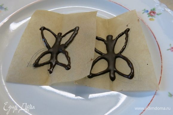 Наполняем мешочек шоколадом и рисуем на пекарской бумаге, с обратной стороны рисунка, бабочек. Слегка сжимаем по намеченному ранее сгибу. Застывать бабочки "летят" в холодильник на 10 минут :)