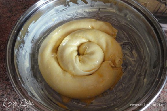 Противень или любую удобную форму для запекания смажьте сливочным маслом и уложите рулеты спиралью. Смажьте сверху желтком.