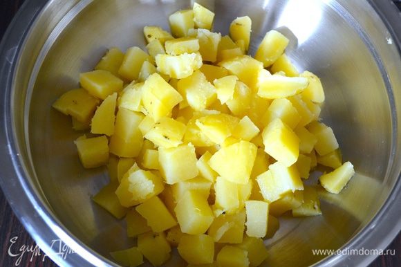 Картофель очистить от кожуры и нарезать небольшими кубиками. Выложить в большую миску-салатник.