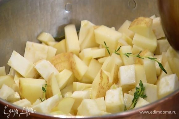 Картофель вымыть и, не очищая, нарезать маленькими кубиками, затем добавить в кастрюлю, все перемешать и продолжать готовить под крышкой.