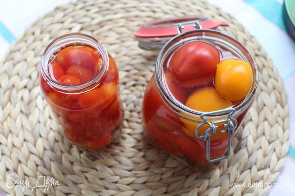 В стерилизованные банки уложите помидоры черри и залейте кипятком на 5 минут.