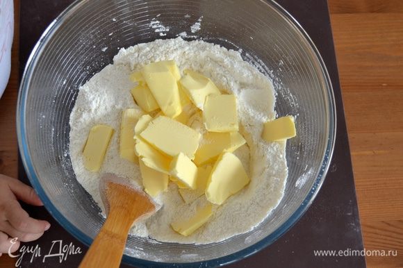 Первым делом просеять в миску муку, добавить сахар и слегка размягченное сливочное масло кусочками.