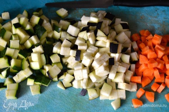 Подготовить первым делом овощи: вымыть цукини, баклажан и морковь (овощи берите не самые крупные). Морковь очистите и нарежьте небольшими кубиками. Цукини и баклажан также нарезать маленькими кубиками.